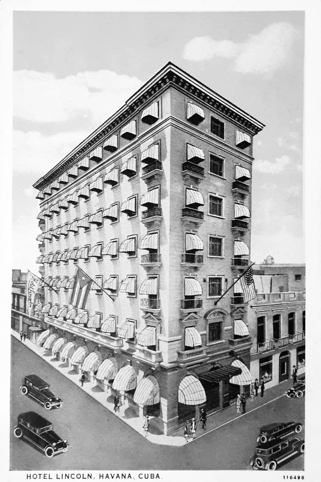 A postcard view of an eight-storey hotel on a street corner: striped awnings over every window, iron balconies, two flags on poles from the upper floors, a vertical sign reading Lincoln at the left end, an entrance canopy on the corner, pedestrians and 1920s cars in the street; the printed line below reads Hotel Lincoln, Havana, Cuba.