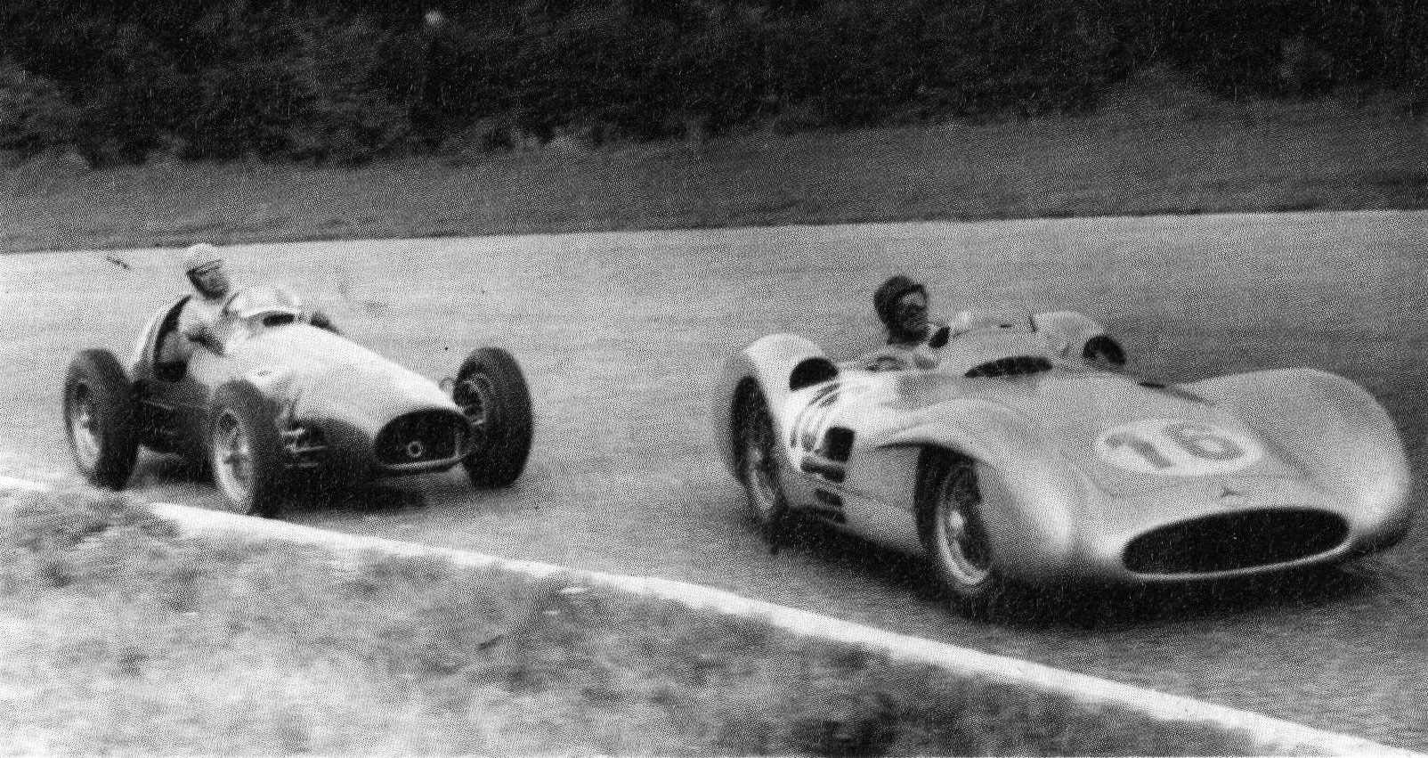 Two cars side by side on the track: on the left an open-wheeled racing car with its driver hunched in the cockpit; on the right a streamlined, all-enveloping car numbered 16, its driver in a dark helmet; dark trees behind.
